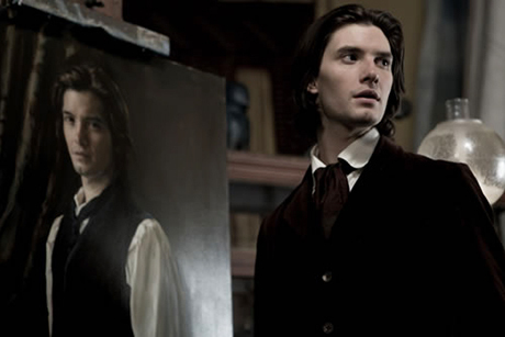 Ben Barnes de pé ao lado de um retrato seu