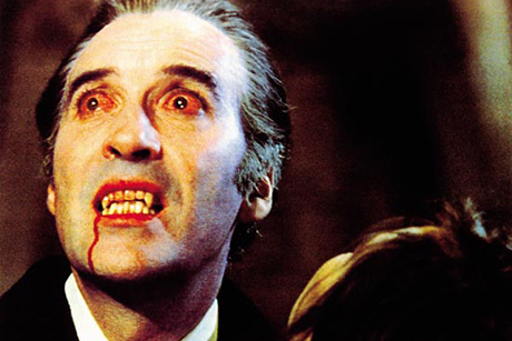 Christopher Lee com olhos vermelhos e sangue nos dentes